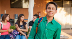 Pre-teen boy happily hanging out at school with some friends