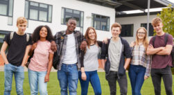 Diverse highschool age kids staning together and smiling